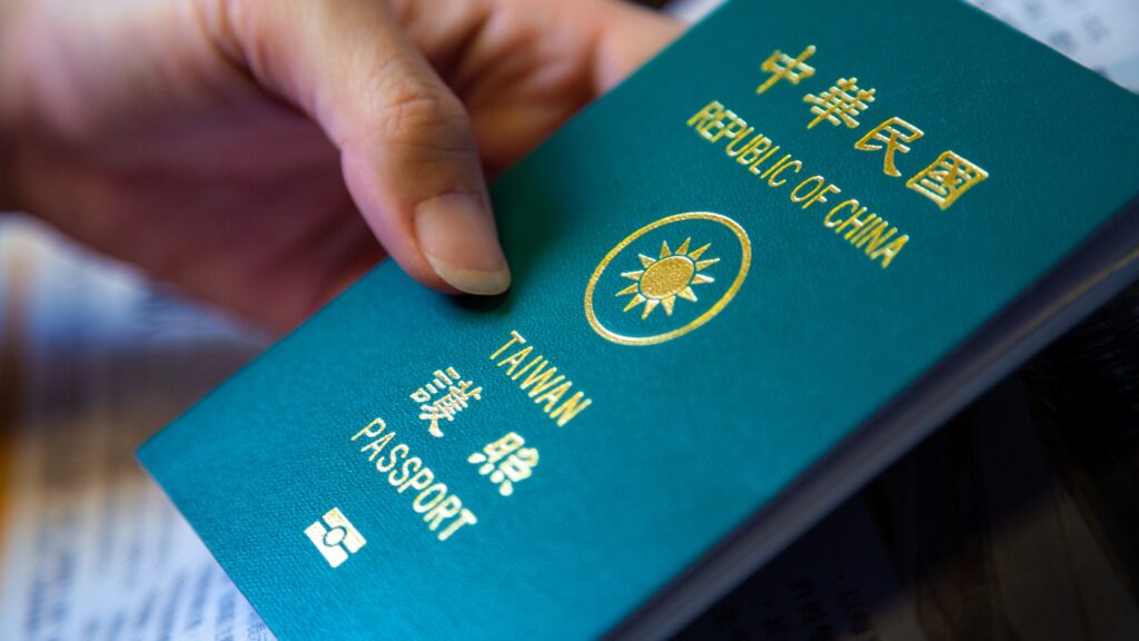 Asian woman's hand hold her Taiwan green passport. Travel foreign countries